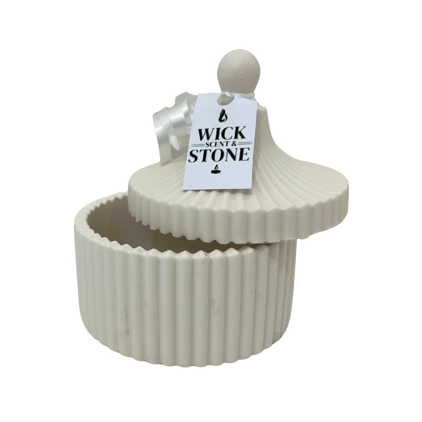 Jesmonite ribbed container with lid and 'Wick & Stone' tag on a white background