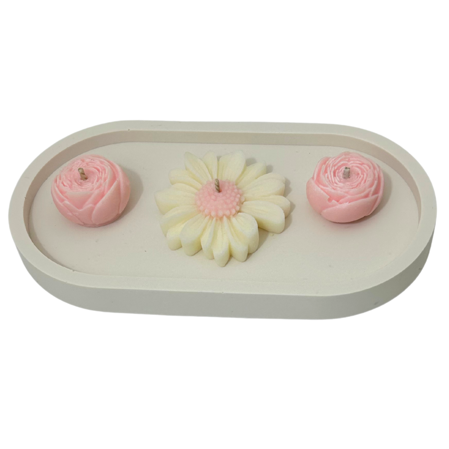 Three floral-shaped candles on a white tray with a white background
