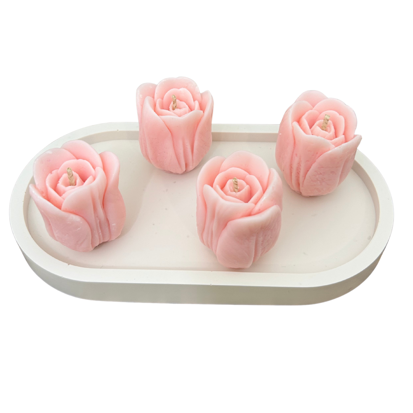 Four pink tulip-shaped candles on a white tray with a white background