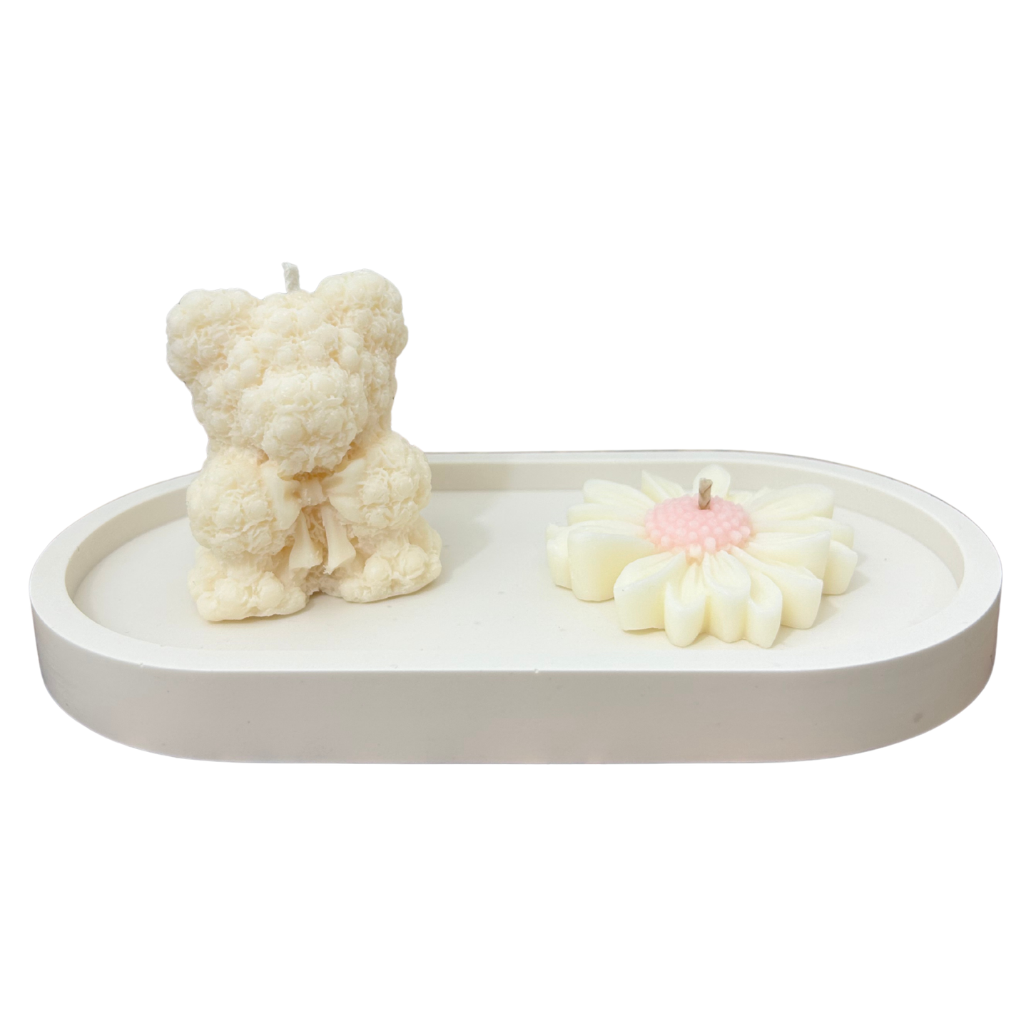 Two unique candle sculptures on a white tray with a white background