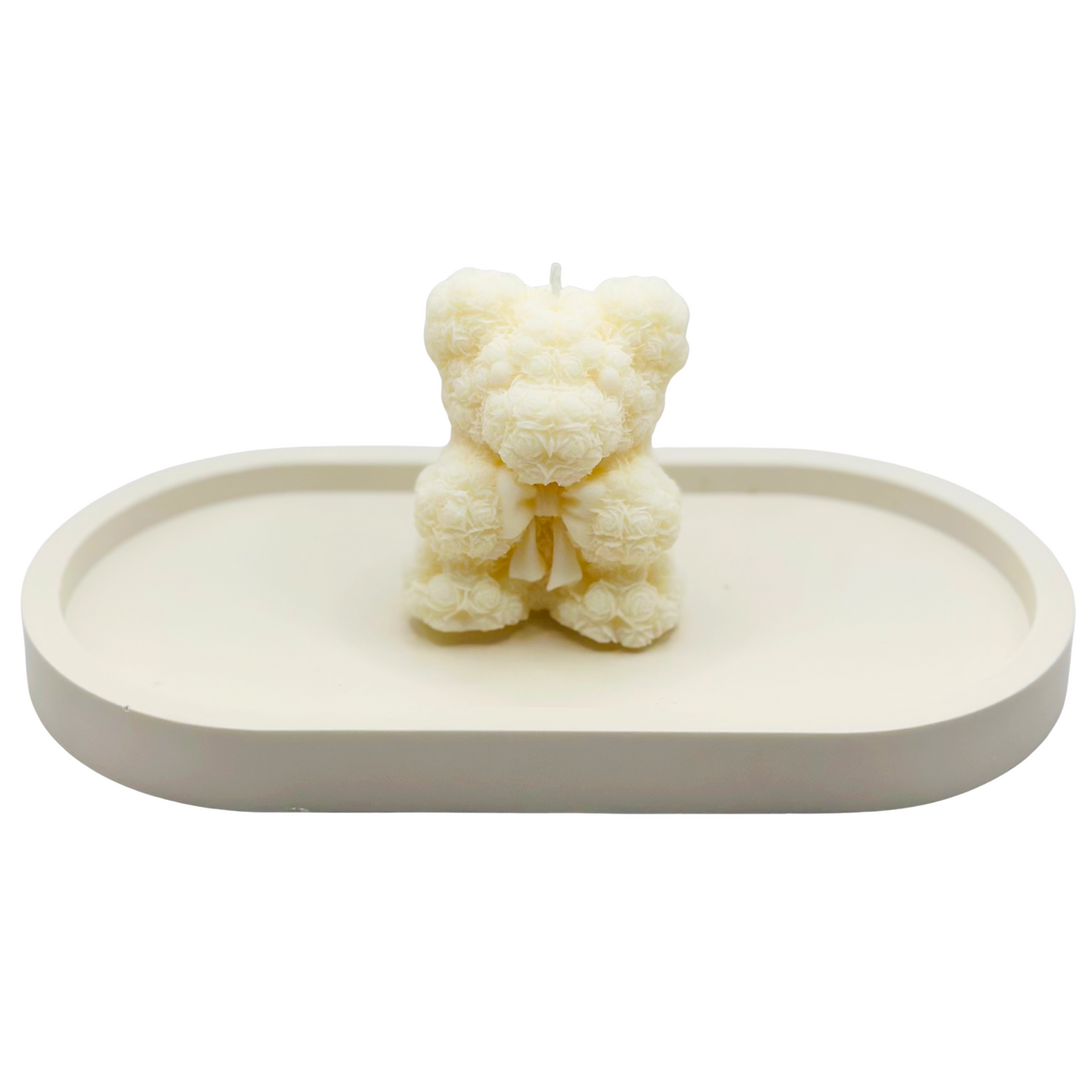 White bear-shaped candle on a white tray with a white background