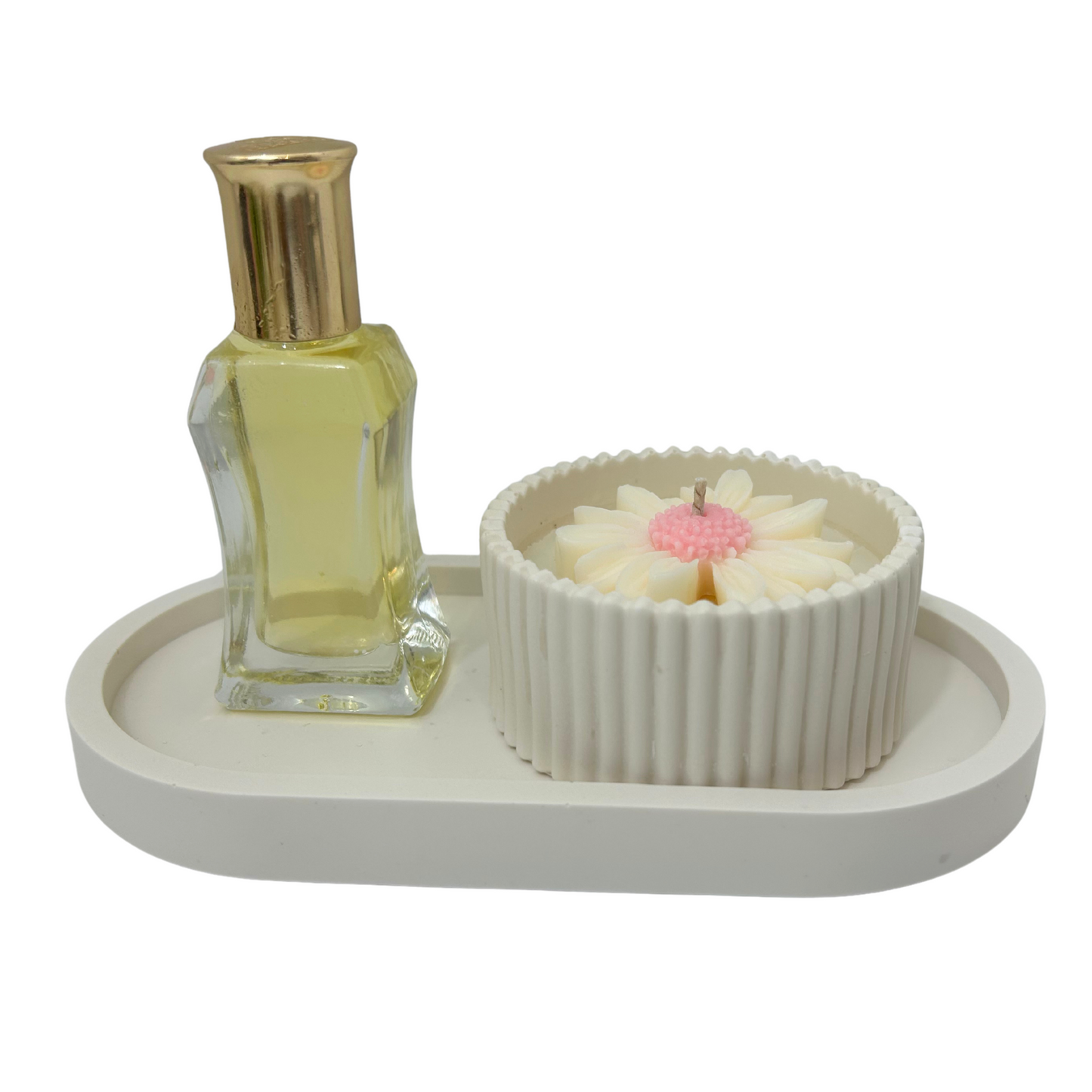 Perfume bottle and decorative bowl with candle on a white tray