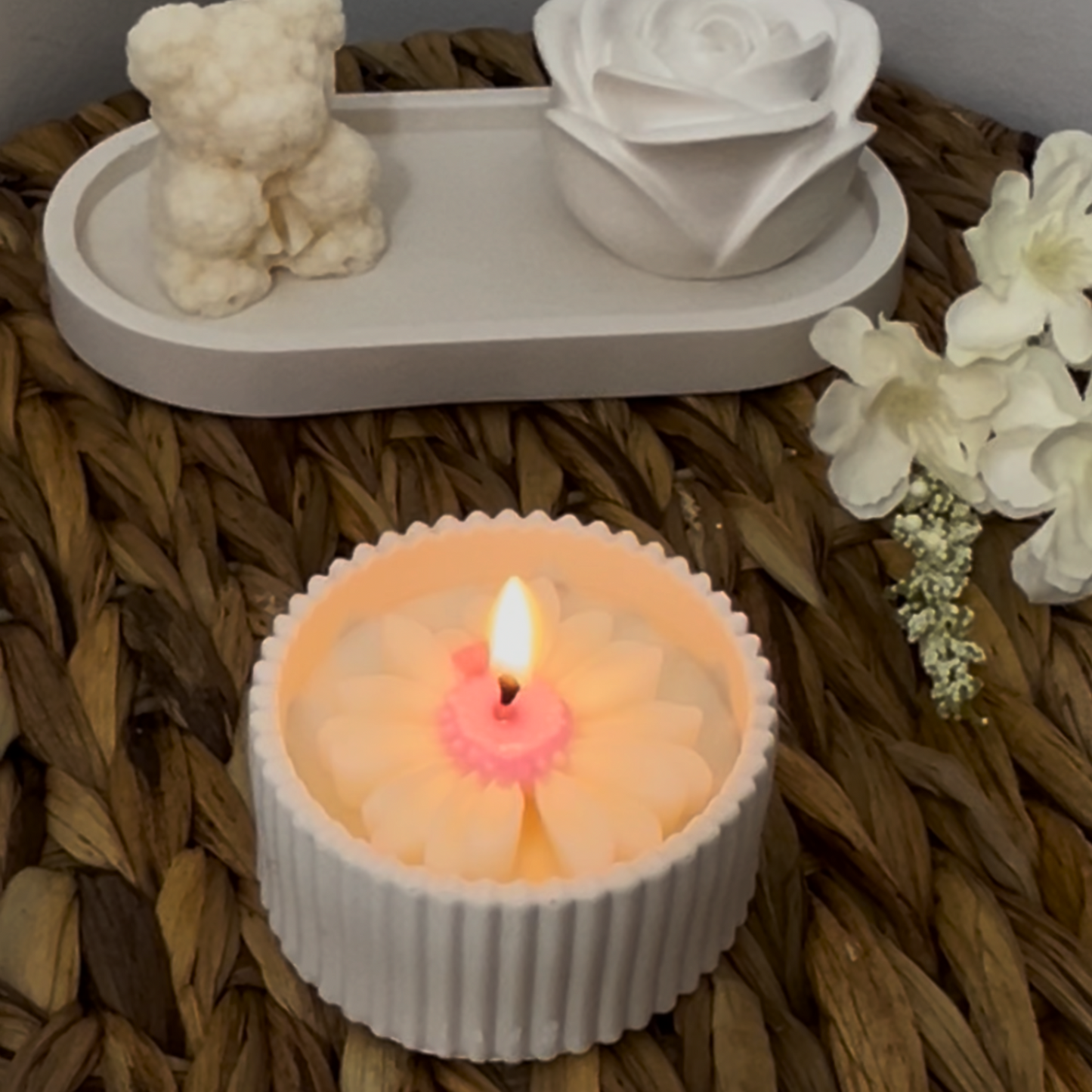 Flower-shaped candle with a wicker surface and decorative items