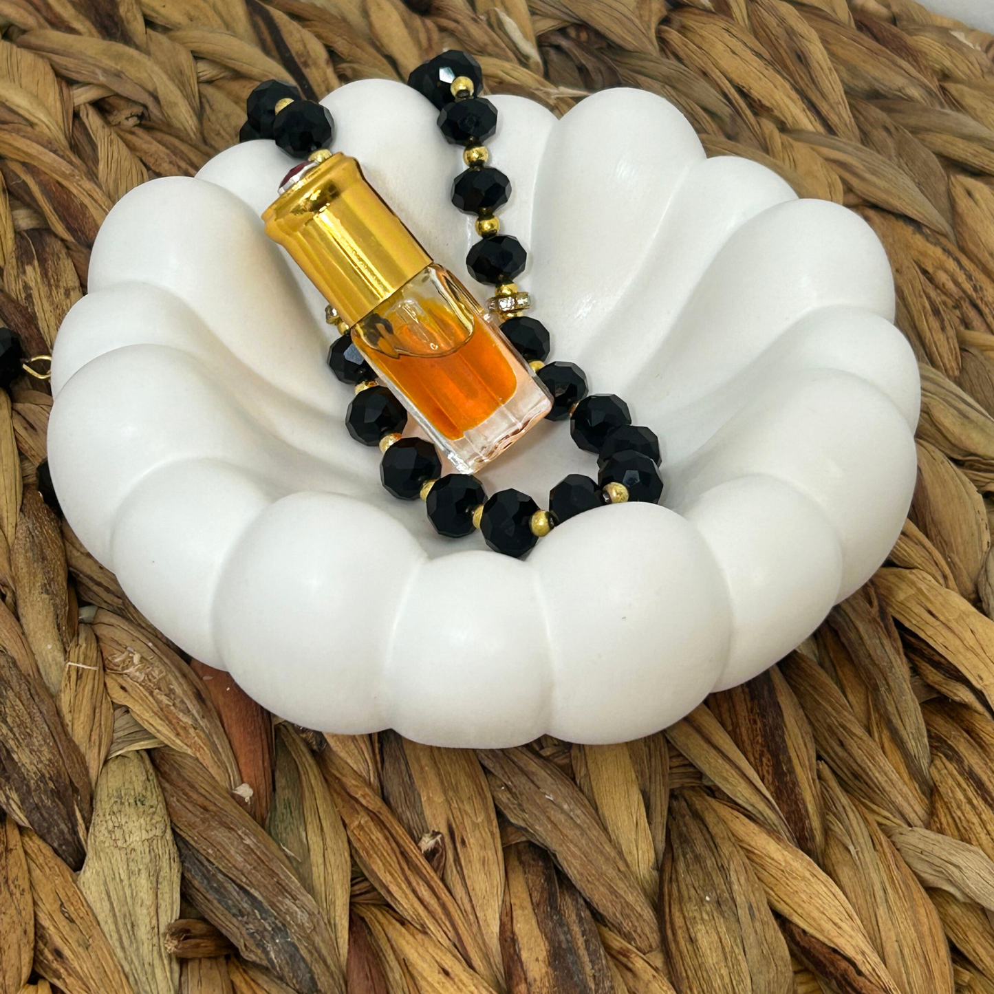 Jesmonite stone bubble trinket jewelry dish with black beads and a gold bottle