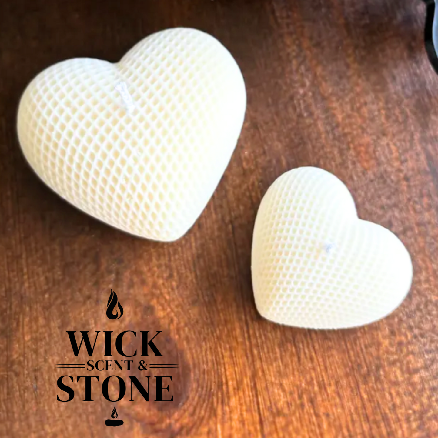 Two heart-shaped candles on a wooden surface with 'Wick Scent & Stone' logo.