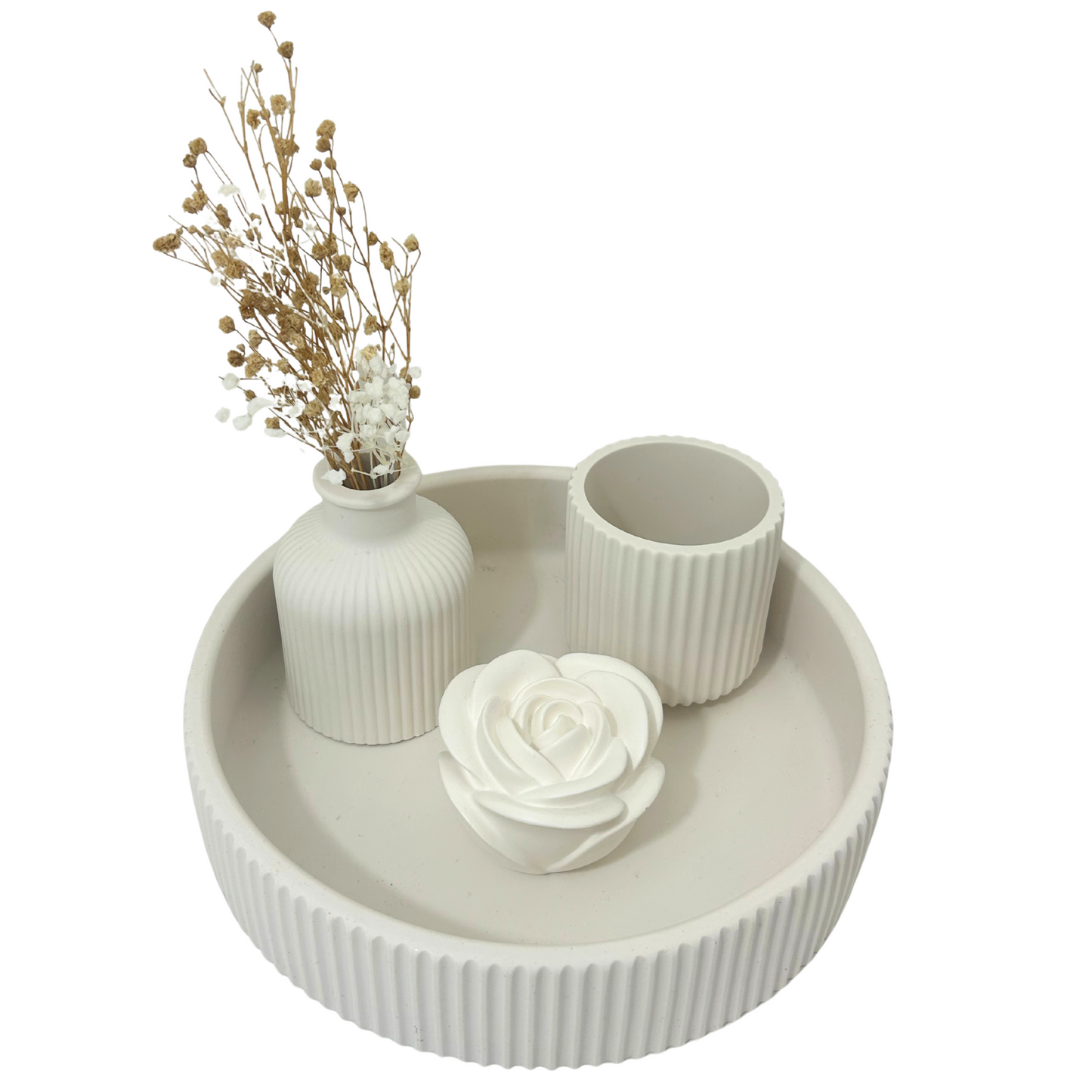 Decorative set with a round white tray, vase with dried flowers, and small cup on a white background