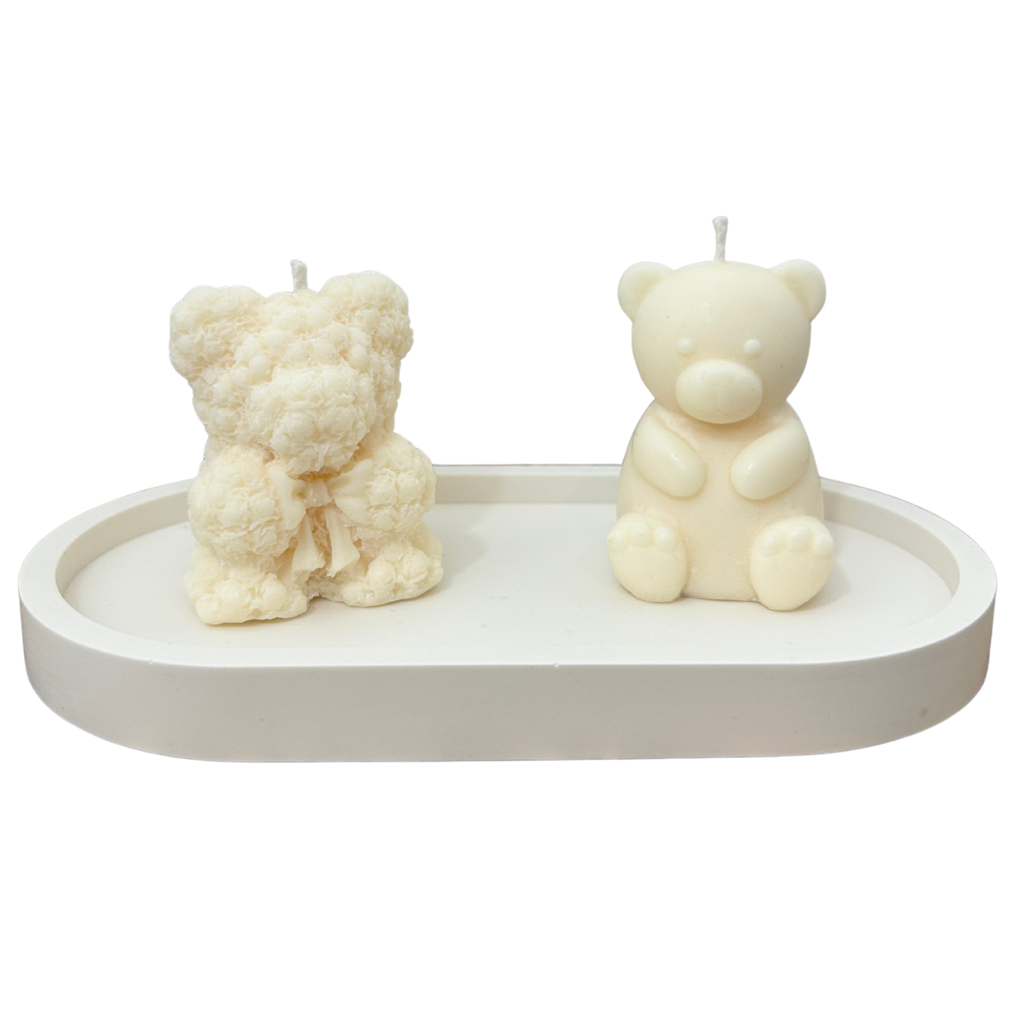 Two bear-shaped candles on a white tray with a white background