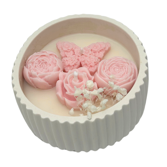 Decorative candle with pink flowers and a butterfly on a white background