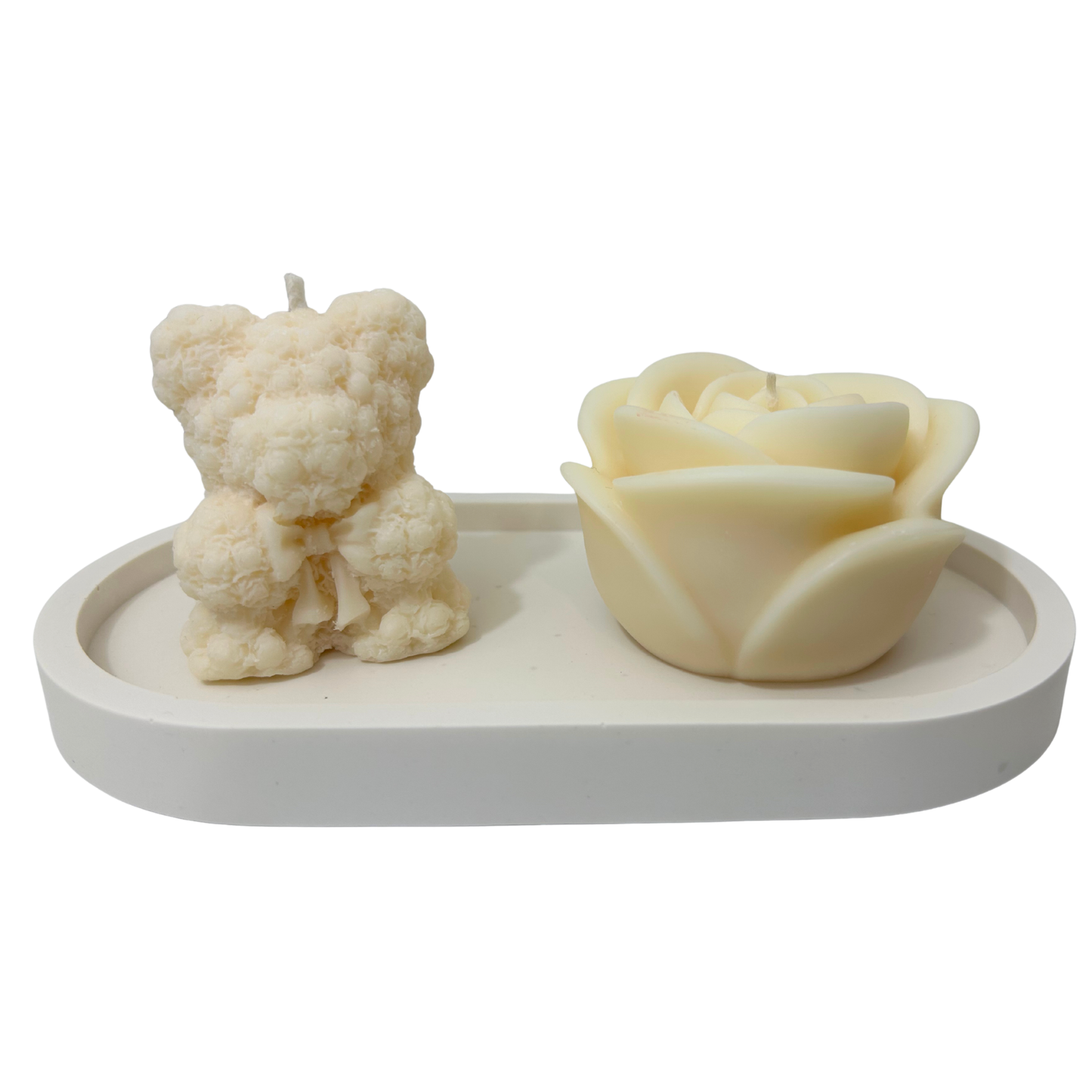 Two candle molds shaped like a bear and a rose on a white tray.