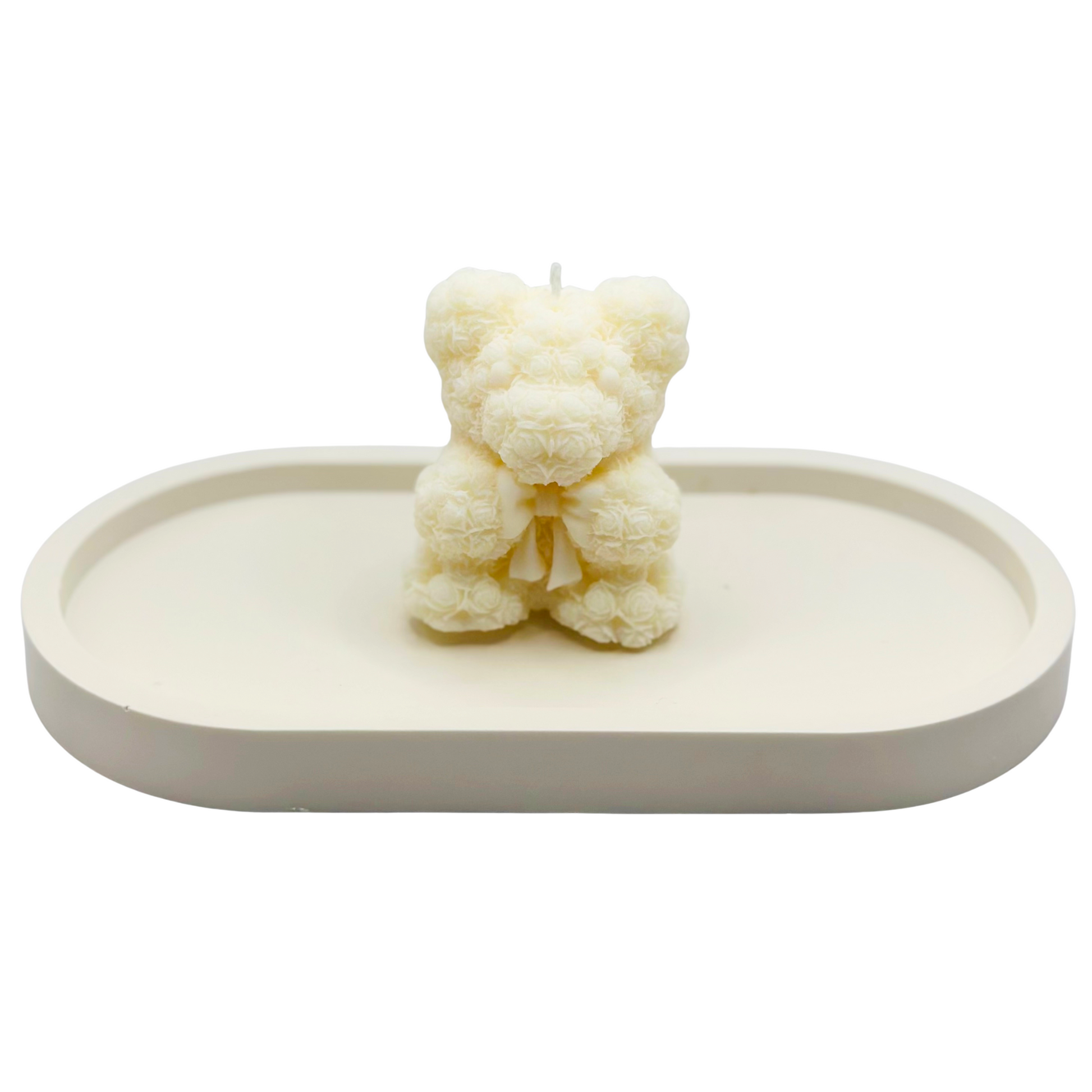 White bear-shaped candle on a white tray with a white background