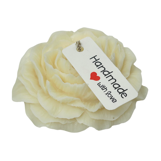 Cream-colored flower-shaped candle with a 'Handmade with Love' tag on a white background