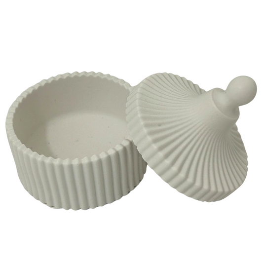 Jesmonite container with shell-shaped lid on a white background