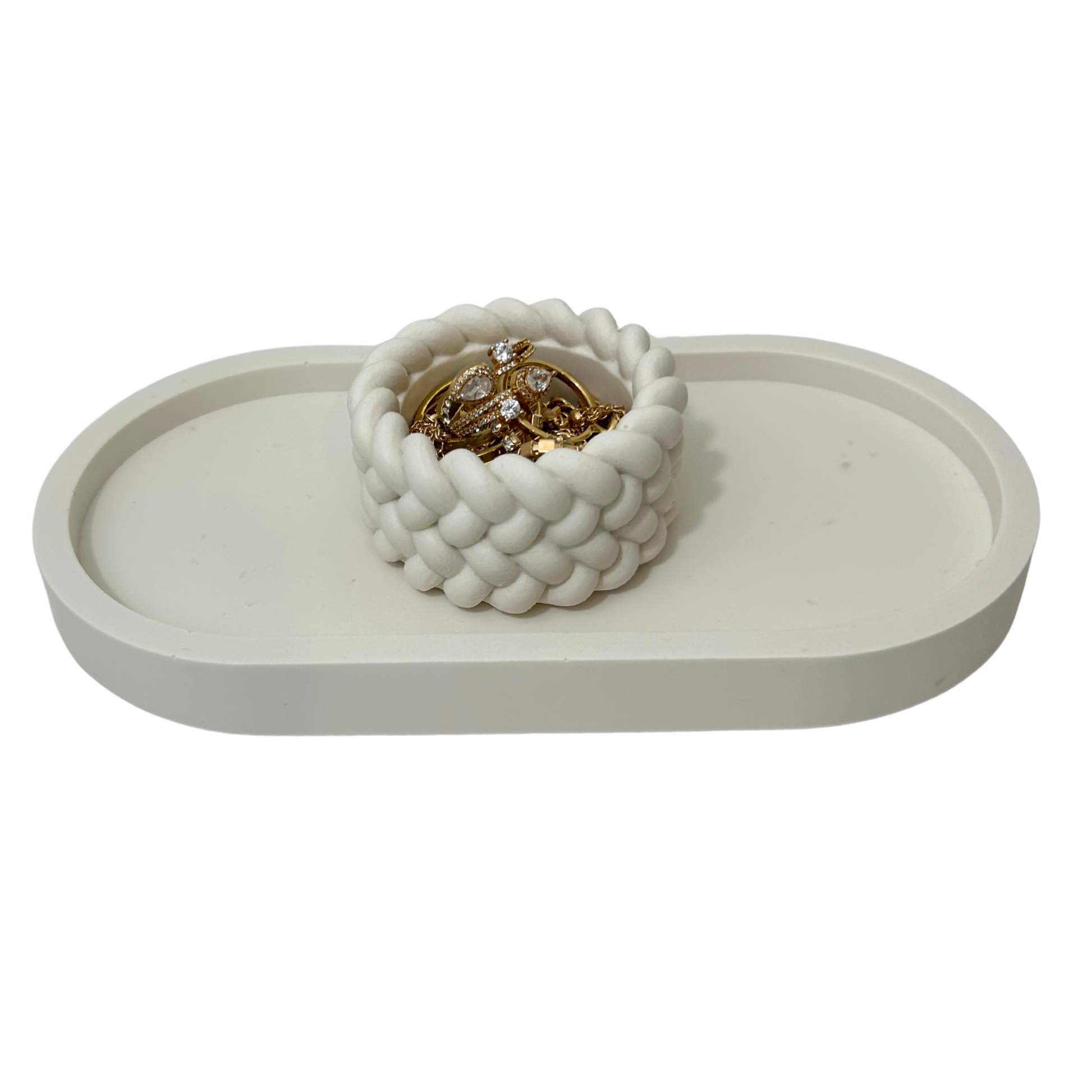 White woven jar with jewelry on a white tray